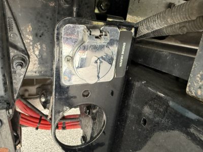 Kenworth T380 engine bay area showing service panel and wiring with label reading 'SERVICE HEATER' and exposed metal brackets.