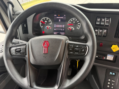 Kenworth T380 steering wheel and dashboard view showing instrument cluster and control buttons.