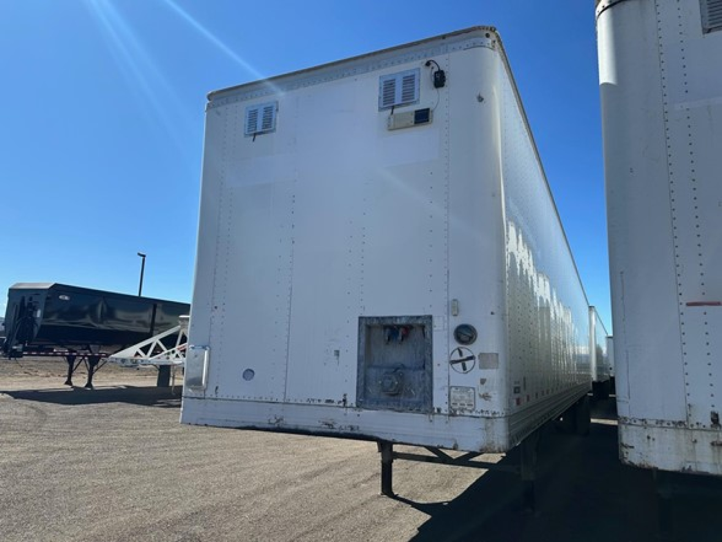 Equipment trailer showing rear view of Hyundai air ride dry van with roll door and white exterior.