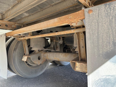 Trailer undercarriage showing rear axle and suspension with air ride components and dual tires.