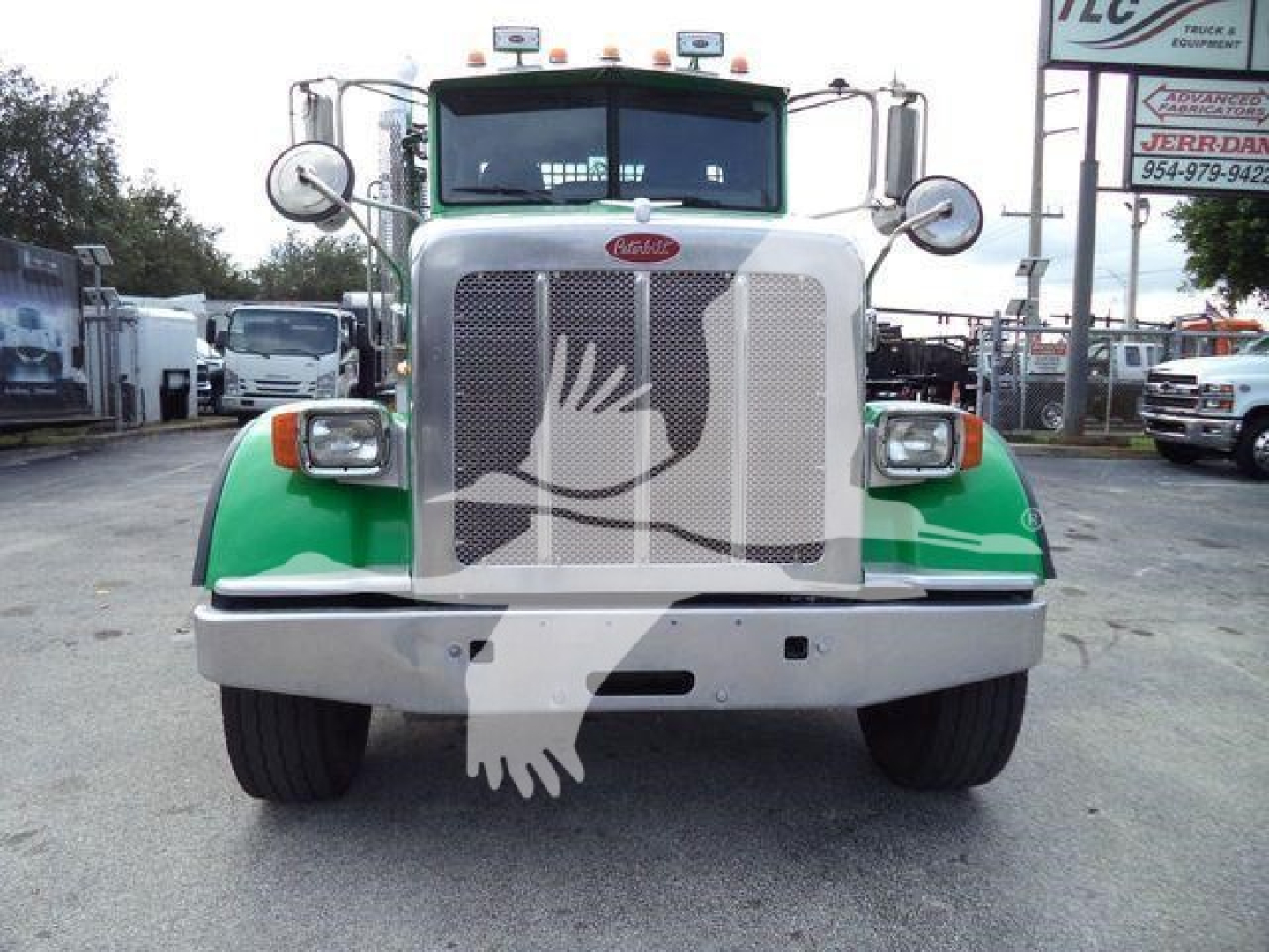 Front view of a white and green Peterbilt 367 truck with large grille, bumper, round headlights, and side mirrors; logo badge centered on grille.