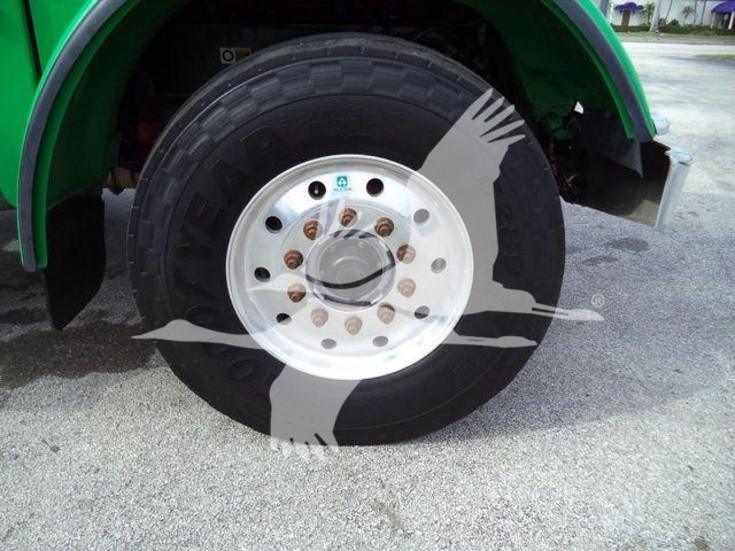 Peterbilt 367 wheel and fender showing green truck body and chrome hubcap with lug nuts; watermark overlay obscures center area.
