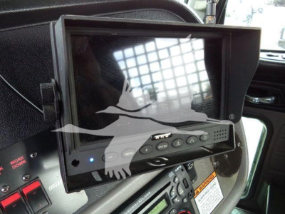 In-vehicle monitor showing navigation/display screen with buttons and a control panel in a Peterbilt truck cab.