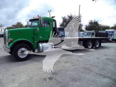 Peterbilt 367 rollback truck in green with front chrome grille and long flatbed; VIN plate and stock number visible in listing.
