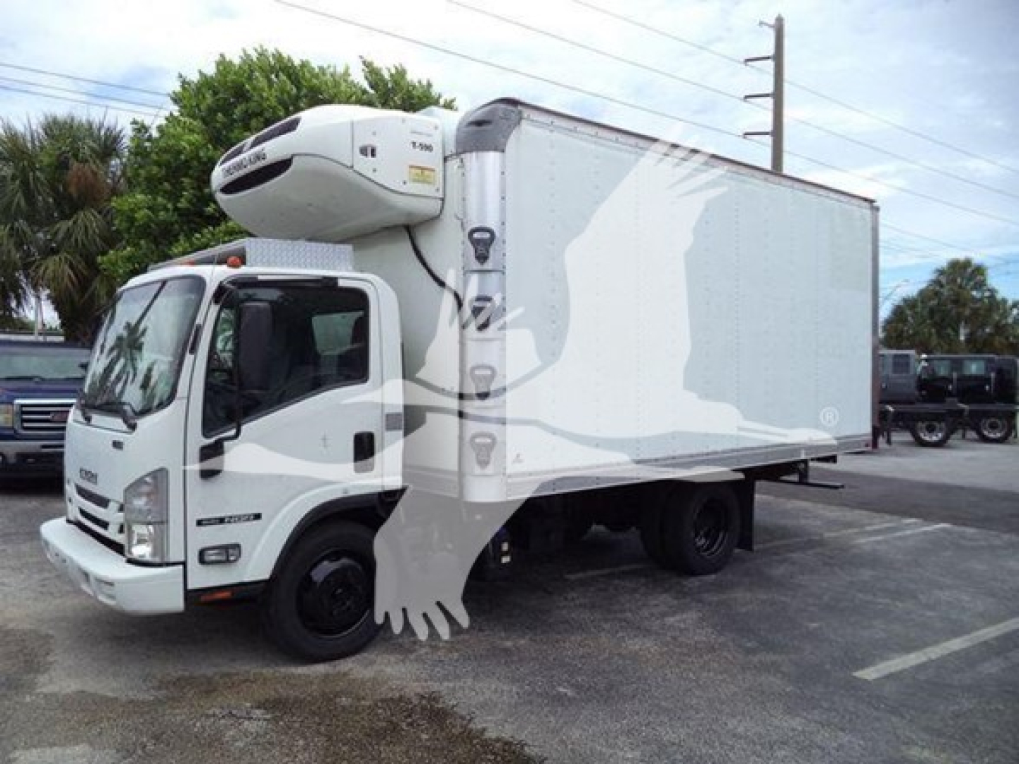 Isuzu NPR-style refrigerated box truck with a white cab and a large freezer box, featuring a front-mounted refrigeration unit on top of the cab; side view shows cargo box with light graphics.