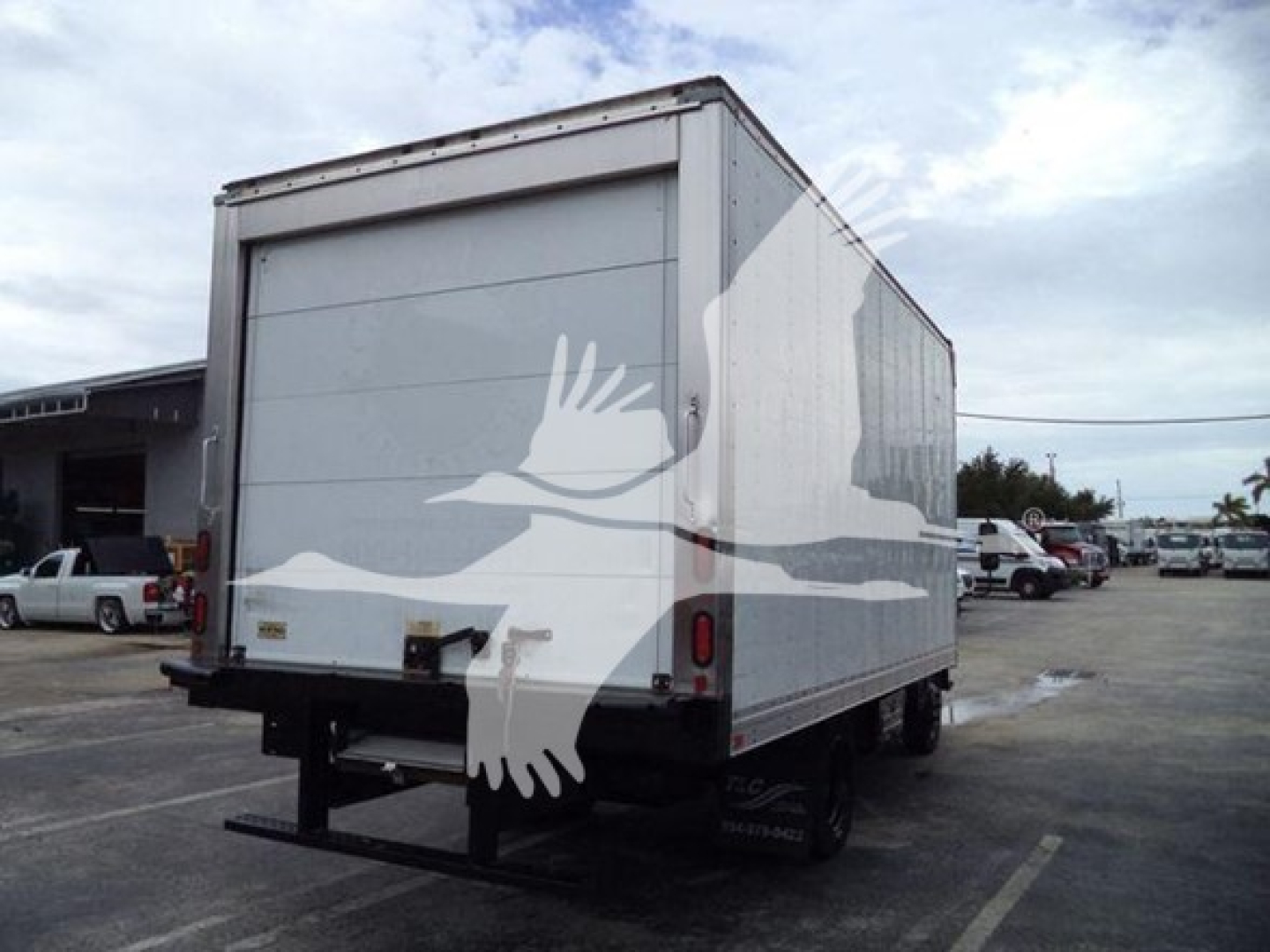 Isuzu NQR refrigerated truck rear view showing roll-up door and dual rear wheels.