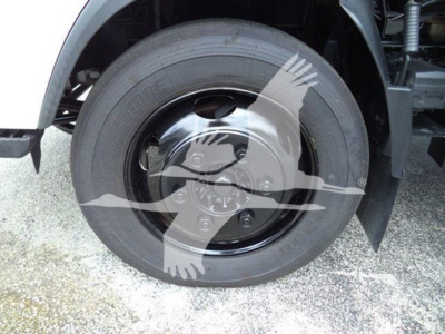 Isuzu NQR front wheel shown with Bridgestone tire and steel hubcap, part of a refrigeration truck.