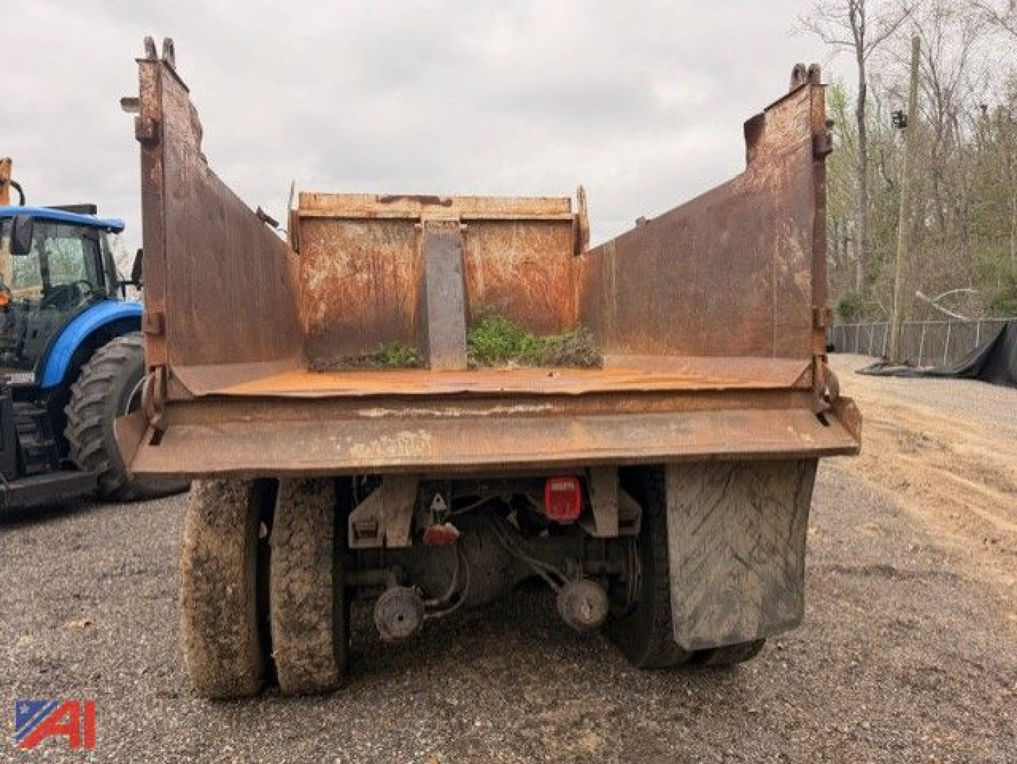 Dump truck bed of a 2003 Freightliner FL80 viewed from rear showing hydraulic hoist and dual rear axles.