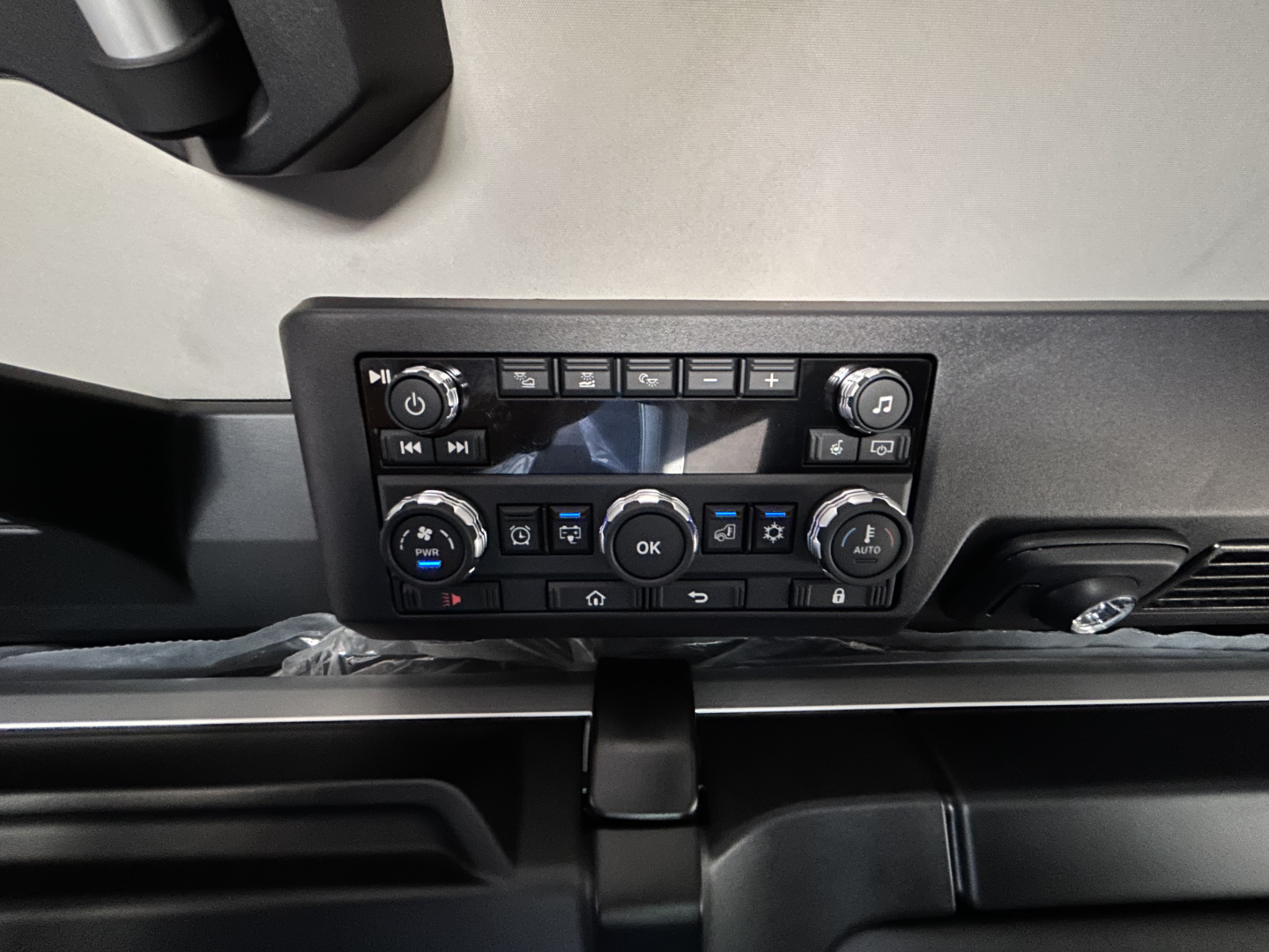 Truck cab dashboard cluster control panel with climate and media buttons in view