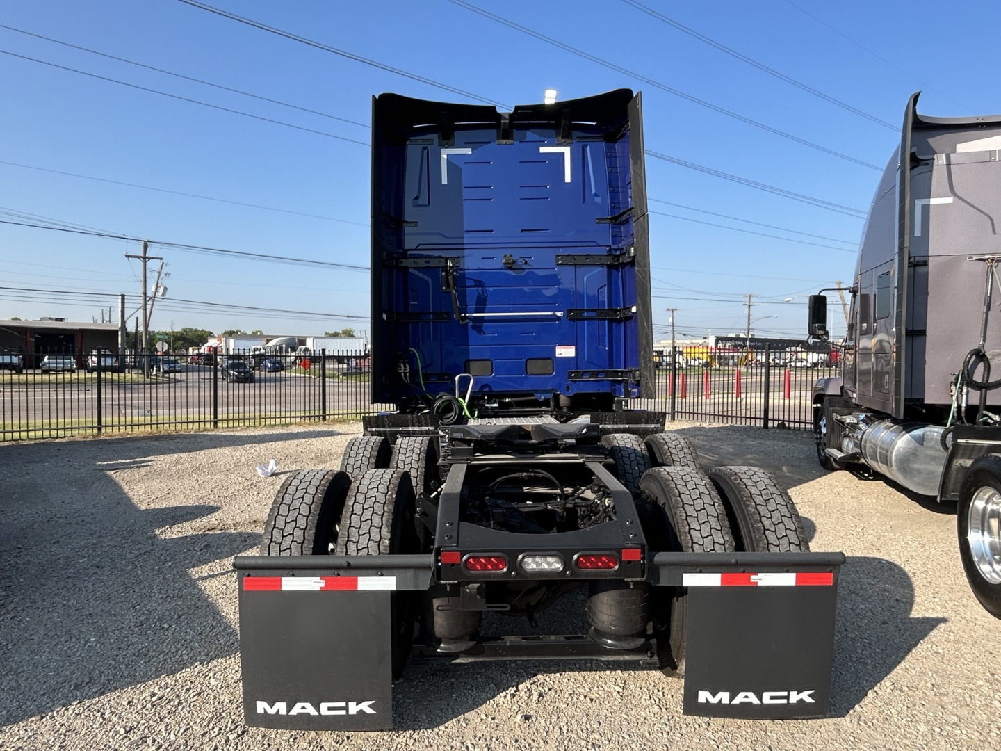 Mack PR64T76H truck chassis rear view showing dual rear wheels and mud flaps with Mack branding.