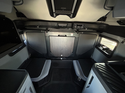 Cab interior of a new 2027 Mack PR64T76H sleeper truck showing front dash controls and seating area with overhead console.