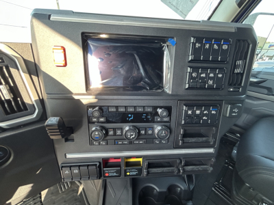 Dashboard and control panel of a 2027 Mack PR64T76H sleeper truck showing climate controls, switch panels, and electronic display.