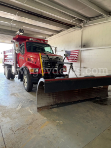 Truck cab with snowplow blade in front, red Sterling L7500 dump truck in a workshop, VIN 2FZAATAK34AM63427, stock number 32896-1.