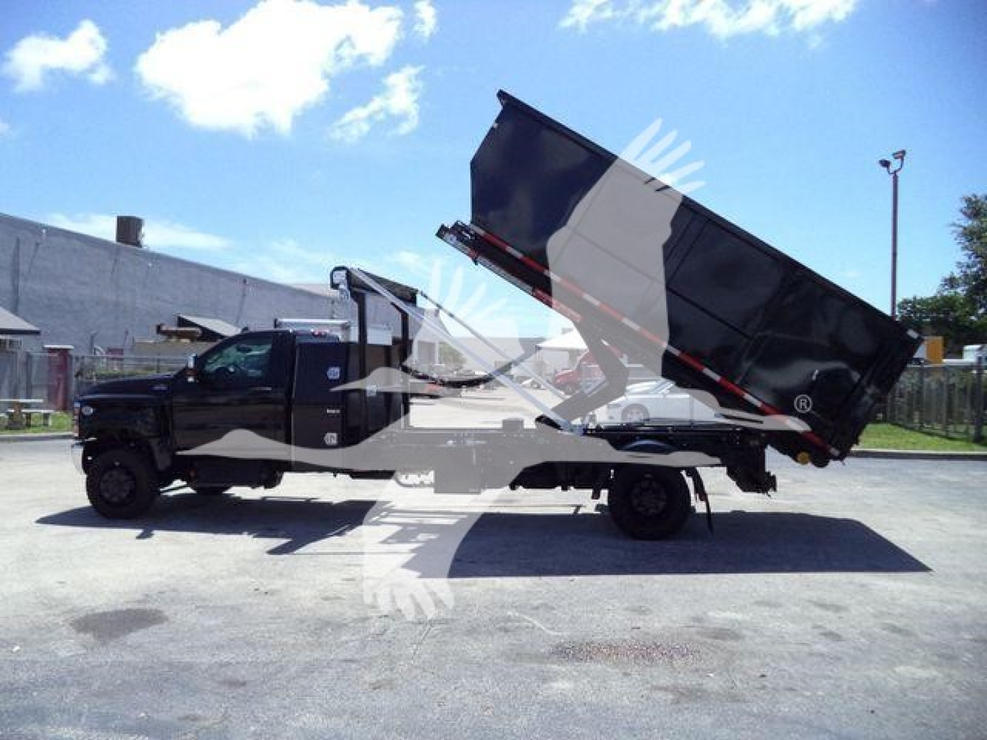 Truck with a raised dump bed on a roll-off truck showing the CV515REG14SNG1 stock number and new condition.