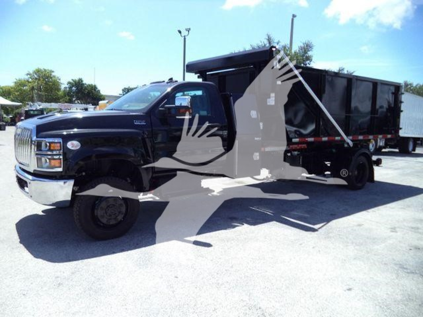 Truck cab and roll-off body showing International CV Series dump truck in black with a long dump container.