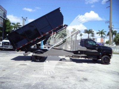 Truck with a raised dump bed in a side view showing the dump truck configuration and brand markings.