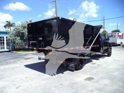 Black dump/roll-off truck in a dealership lot, side and rear views visible, with stock number CV515REG14SNG1 in description.