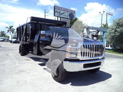 Truck in a dealership lot showing a black dump body with a chrome front grille and # CV515REG14SNG1 visible on a sign in the background.