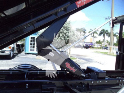Truck hooklift arm and hydraulic component showing Rocky logo and control box with metal frame.