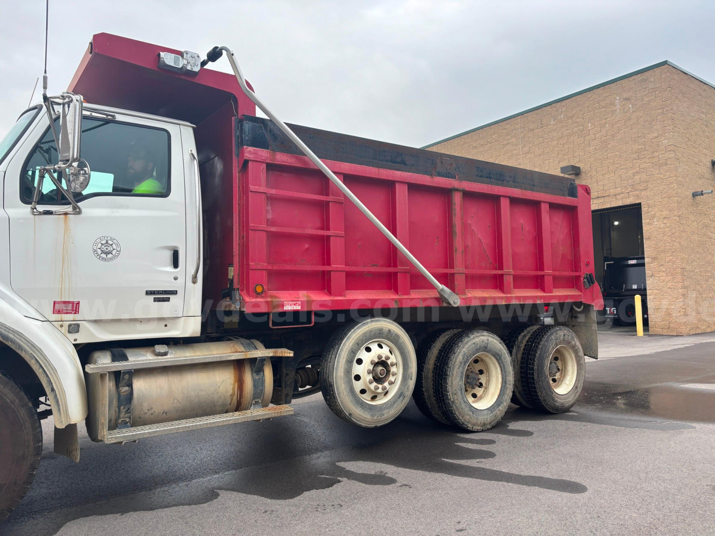 Dump truck side view showing Sterling LT9500 with red dump bed and white cab.