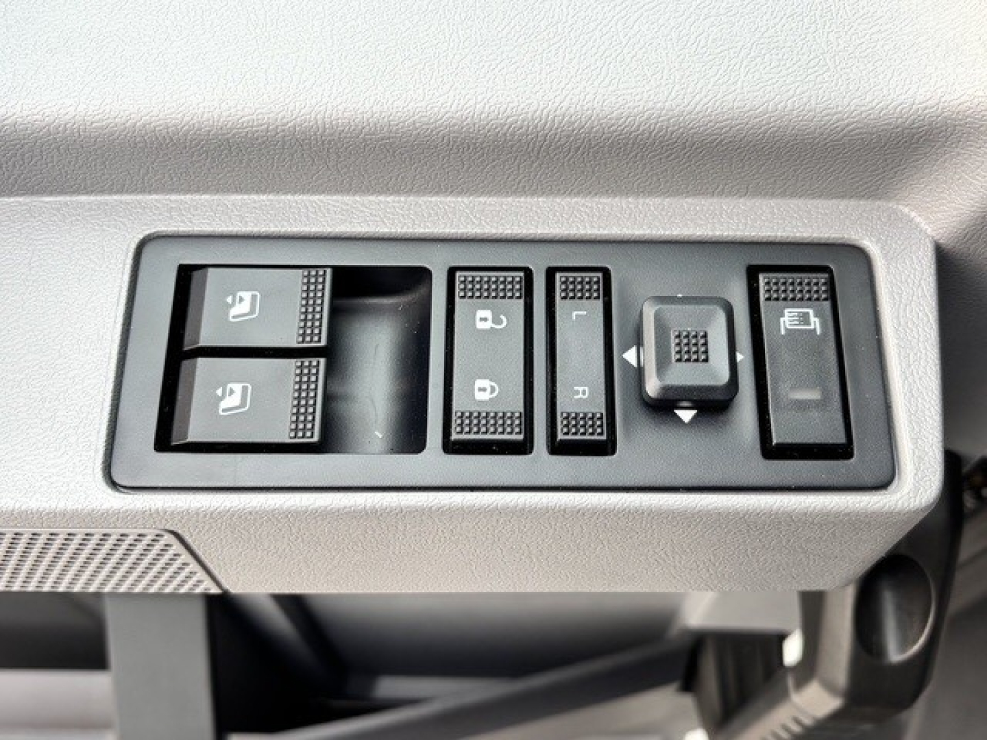 Interior control panel of a Mack GR64B showing window and mirror adjustment switches and seat memory buttons.