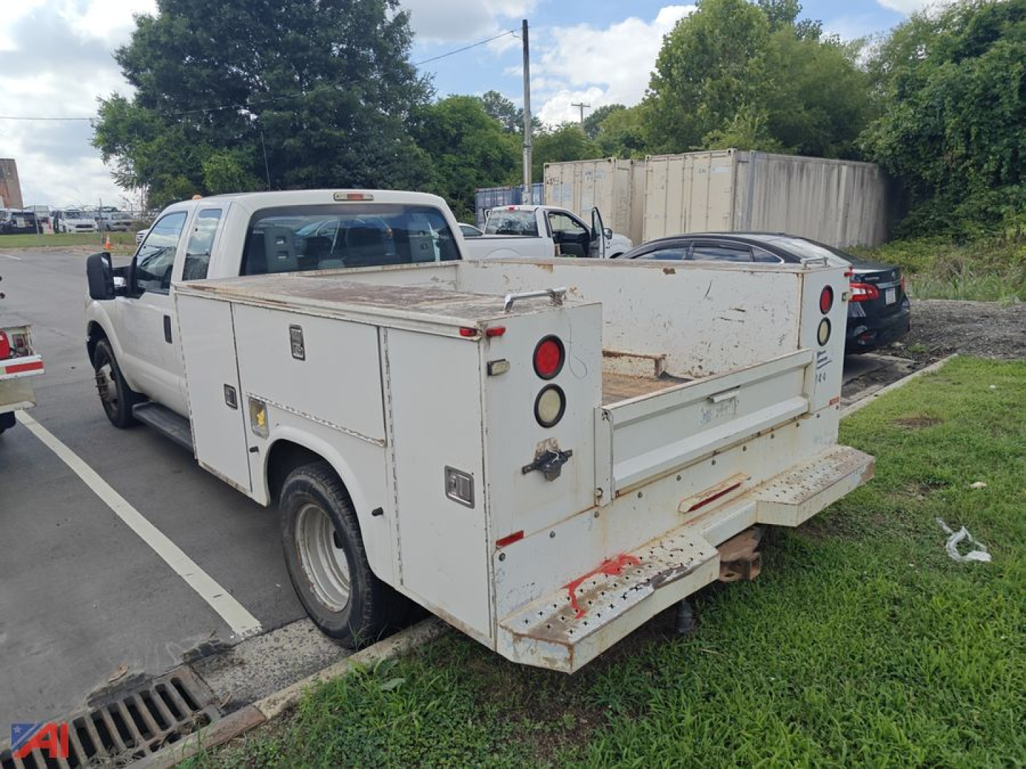 Ford F-350 utility service truck with utility body, rear view showing compartments, toolboxes, and ladder rack platform.