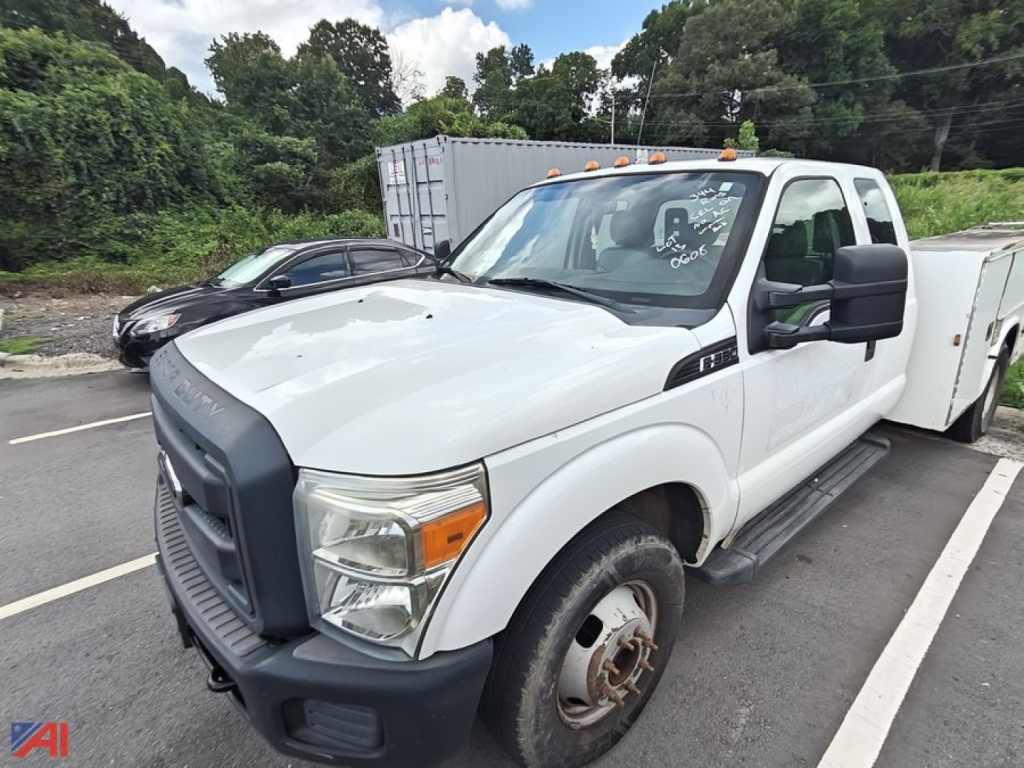 Ford F-350 utility truck front-left view showing extended cab and utility bed with white exterior