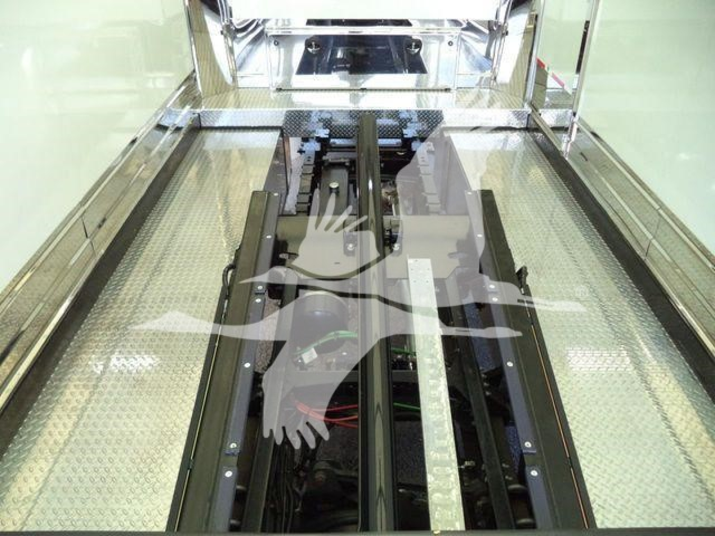 MD6 truck rollback interior showing chassis rails and floor with metallic diamond plate and hydraulic corridors.