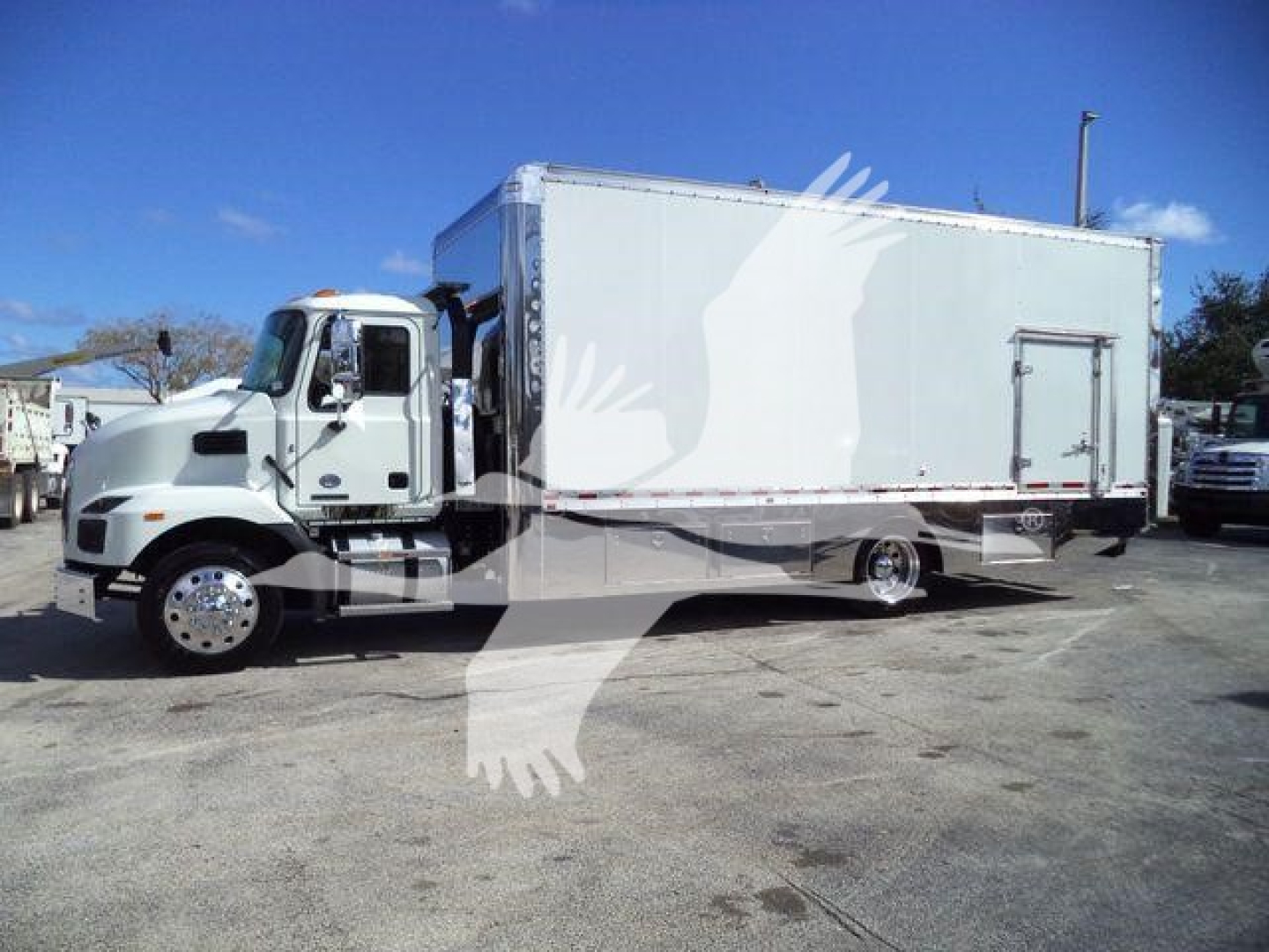 Truck in side view showing a white box truck with a large cargo box and cab; MD6 model branding not visible; dealership lot background