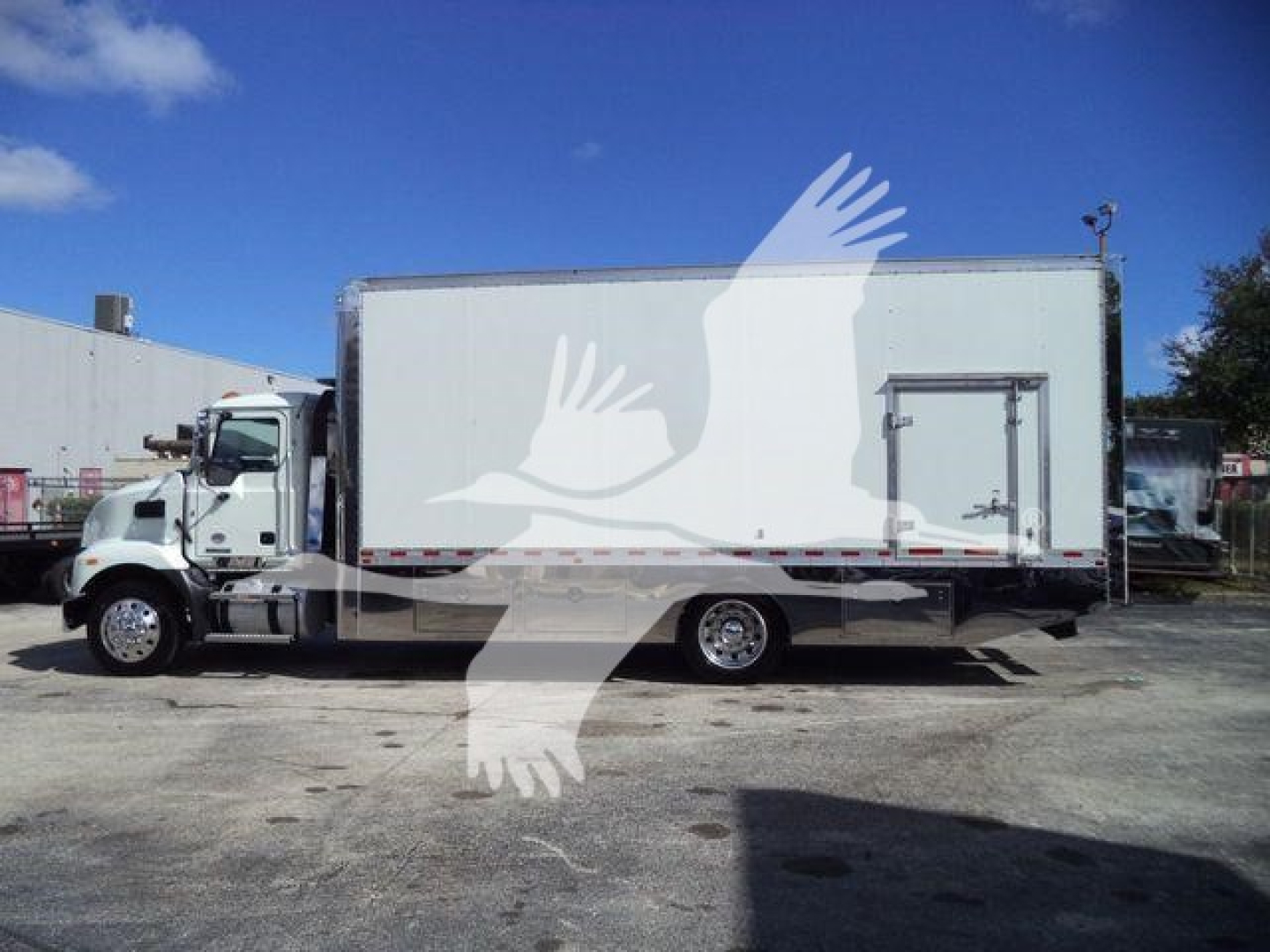 Truck side profile of a 2026 Mack MD6 rollback truck with a large cargo box and front cab visible.