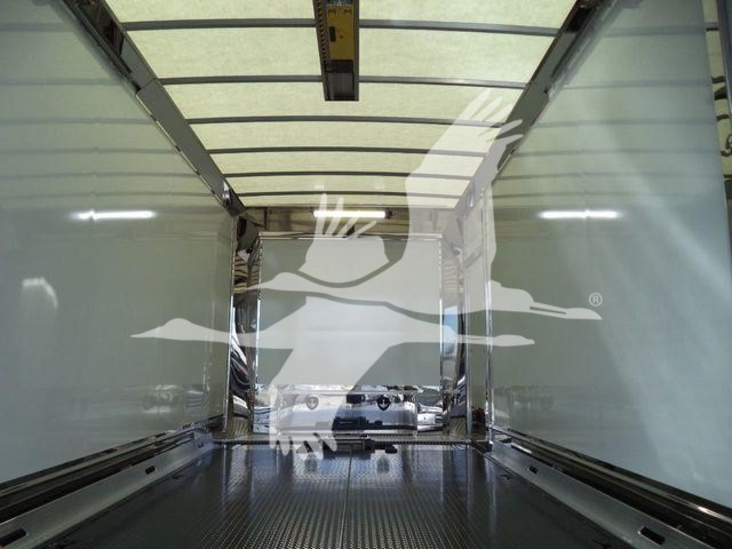 Truck interior cargo area of a new 2026 Mack MD6 rollback truck showing empty box with metal flooring and side rails.