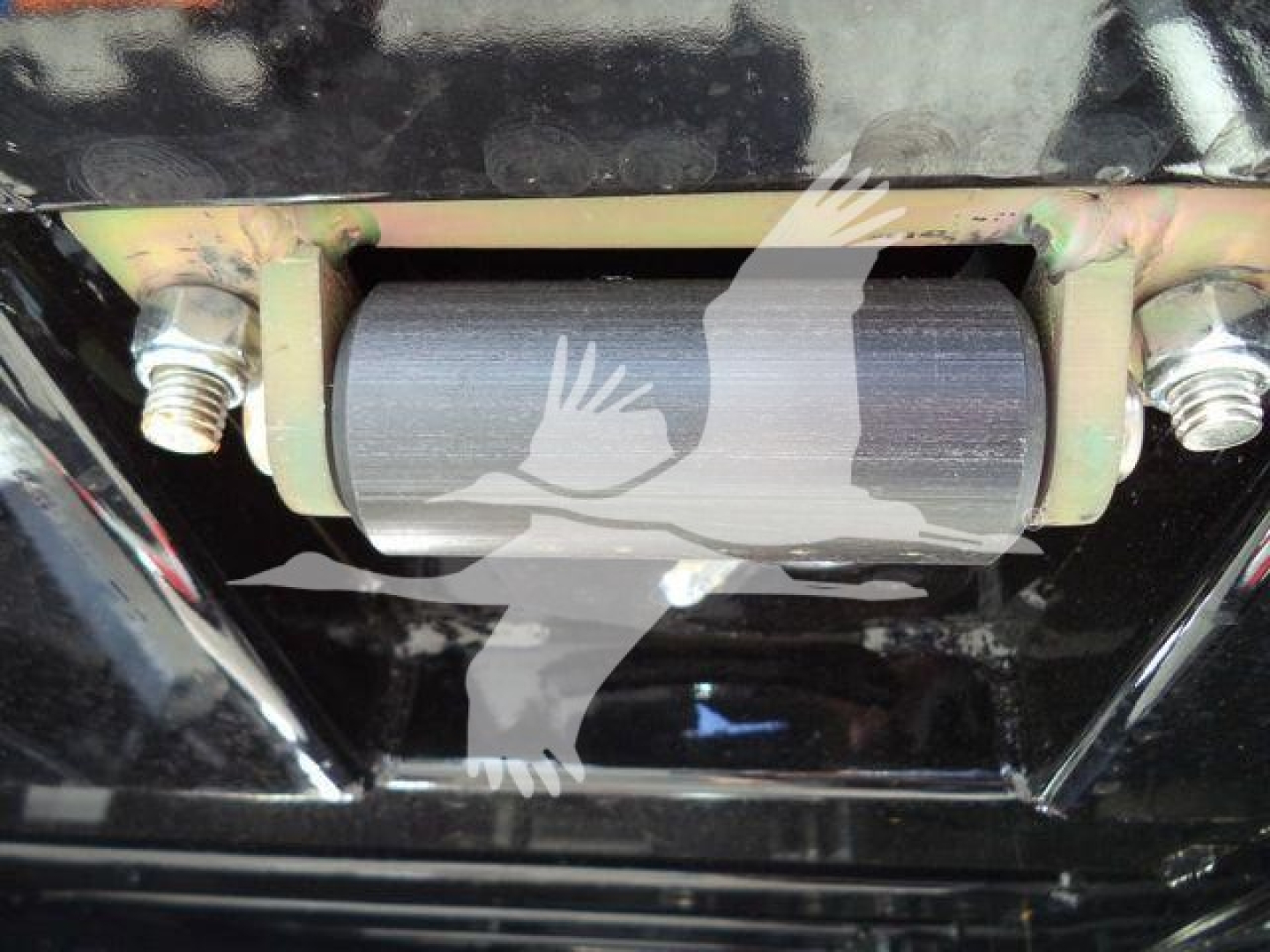 Roll-back tow truck undercarriage showing pulley wheel and mounting bolts.