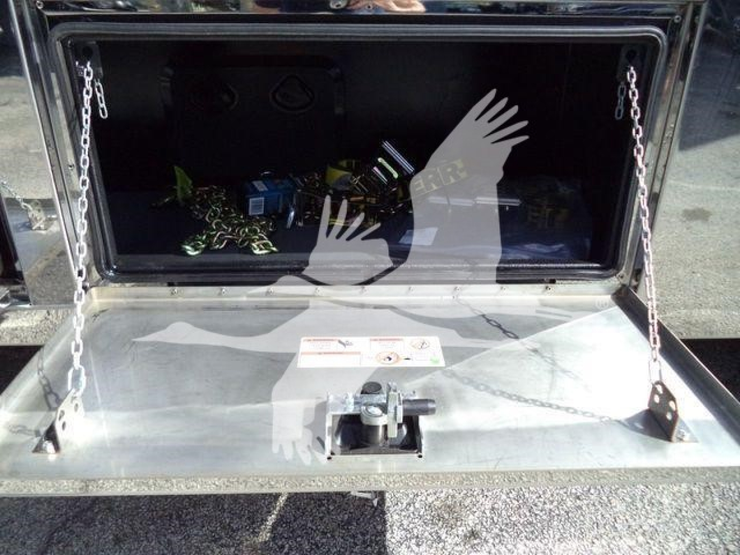 Mack MD6 rollback truck storage compartment open showing interior tools and chains.