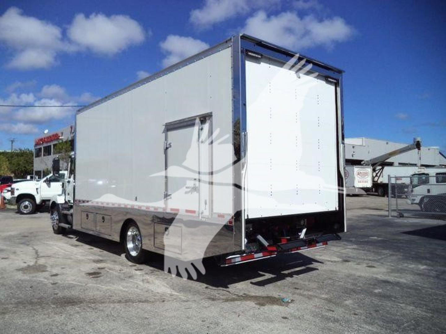 MD6 tow box truck rear and side view showing blank rear roll-up door and white cargo box on a Mack MD6 chassis.