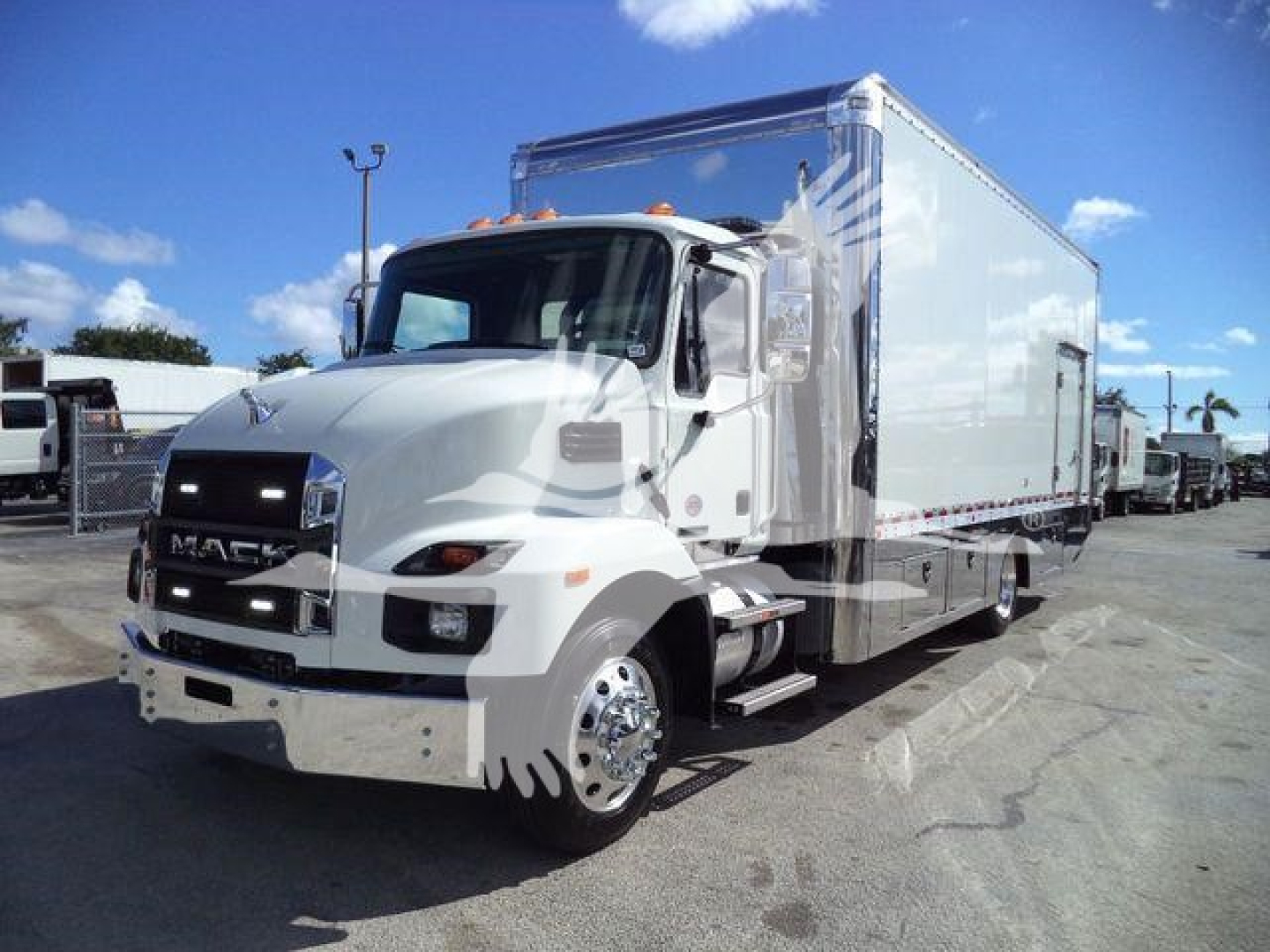 Truck front and side view of a white Mack MD6 cab with a large box, chrome wheels, and a roll-back body.
