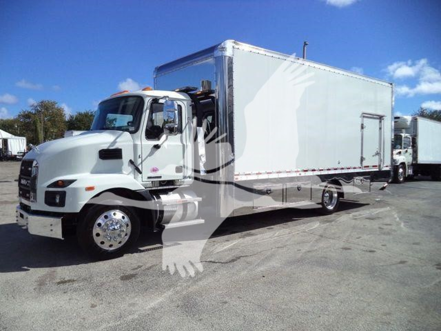 White Mack MD6 truck with a large box body, front cab view, parked outdoors.