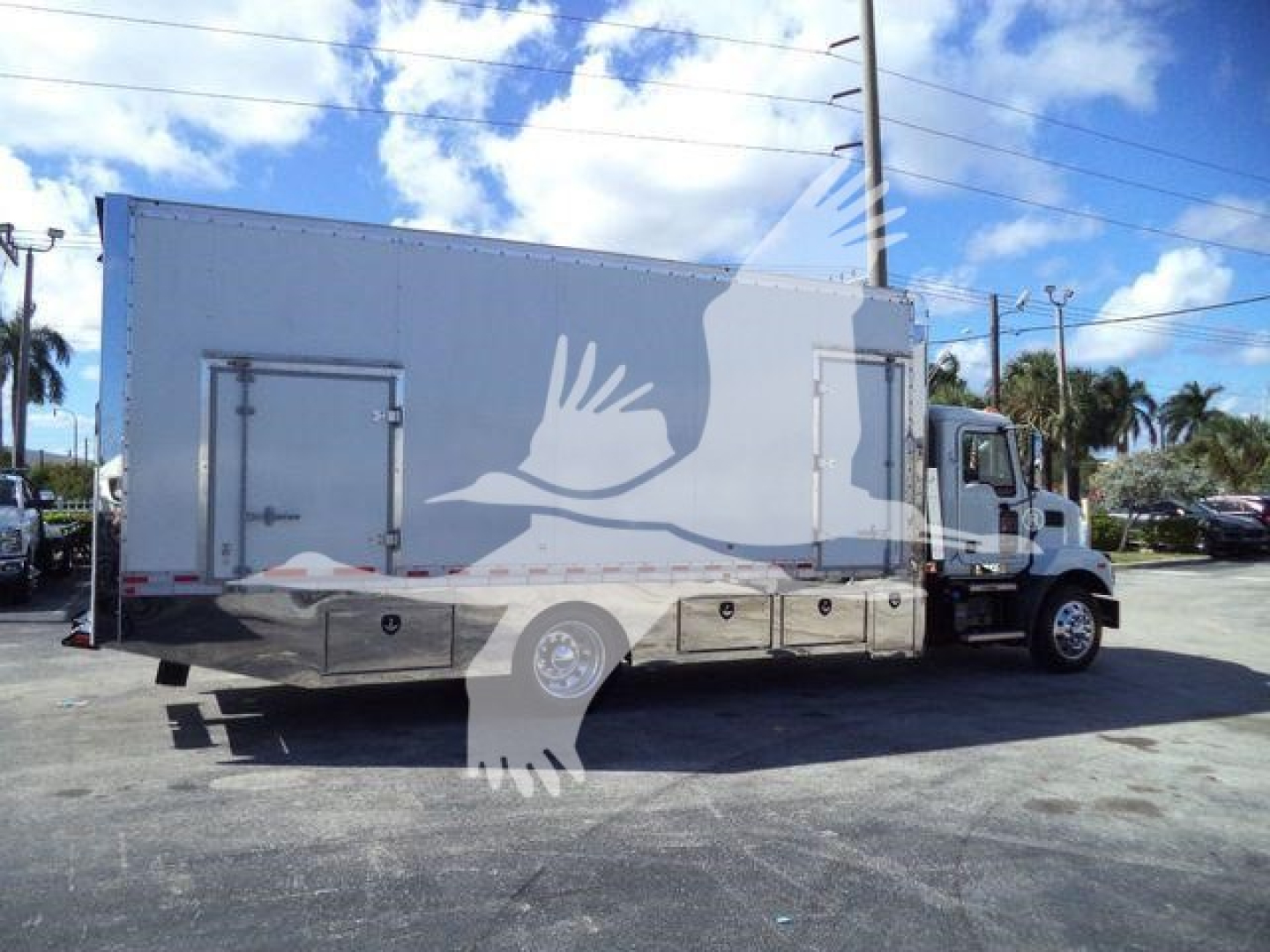 Truck side view showing a large box truck with a rollback utility body, MD6 model, with stock MD6TOWBOX2.