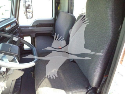 Truck interior showing driver's seat and steering wheel of a 2026 Mack MD6 cab from the driver's side.