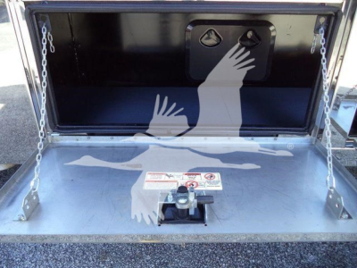 Truck storage bed in open tailgate showcasing interior of MACK MD6 rollback truck with safety chains and mounting hardware.