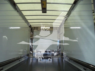Truck interior cargo area of a new 2026 Mack MD6 rollback truck showing empty box with metal flooring and side rails.