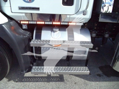 Rear view of a Mack MD6 rollback truck showing diamond plate steps and bumper, with a storage box and taillight strip.