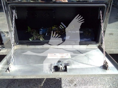 Mack MD6 rollback truck storage compartment open showing interior tools and chains.