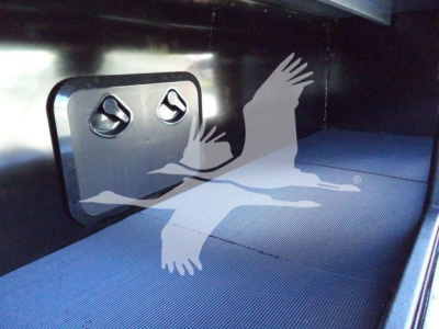 Interior of a Mack MD6 rollback truck showing a blue ribbed floor and a square access hatch with two circular latches.