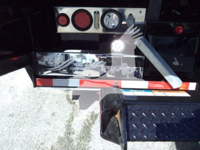 Tail area of a 2026 Mack MD6 rollback truck showing rear lights, control panel, and diamond plate step. Visible text includes MD6TOWBOX2 stock number and equipment branding.