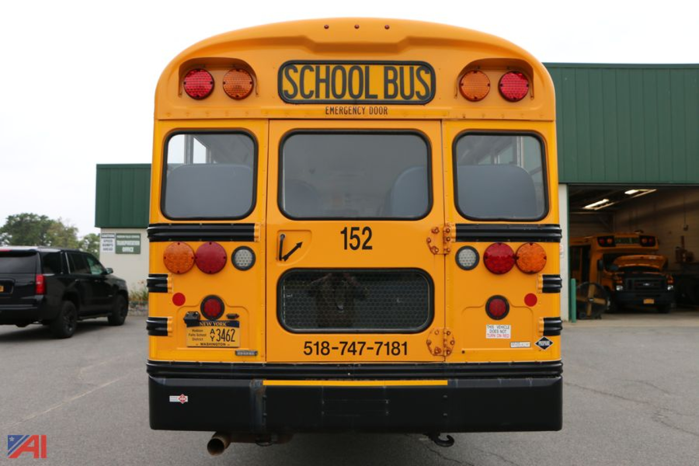 Bus rear showing School Bus sign and taillights, with number 152 and phone number 518-747-7181 visible.