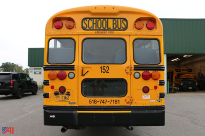 Bus rear showing School Bus sign and taillights, with number 152 and phone number 518-747-7181 visible.