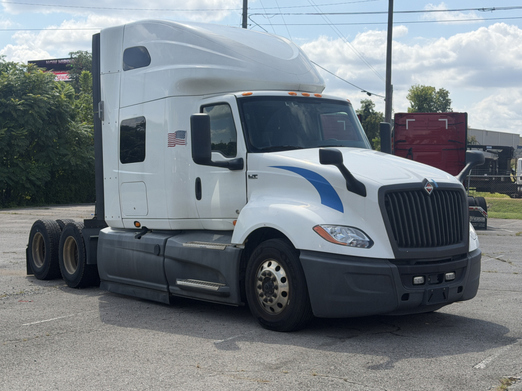 Truck cab of a 2021 International LT625 semi-truck in view with sleeper cab and aerodynamic design, front grille and headlights visible.