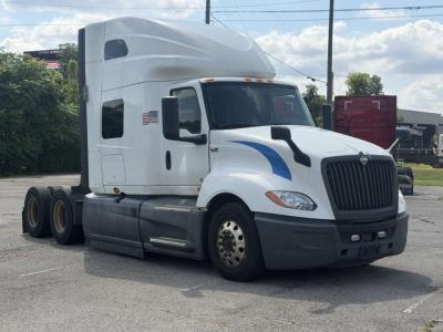Truck cab of a 2021 International LT625 semi-truck in view with sleeper cab and aerodynamic design, front grille and headlights visible.