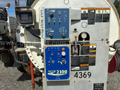 Front panel of a vacuum truck control unit showing blue Vactor 2100 control panel with multiple knobs, switches, and warning labels; number 4369 visible.