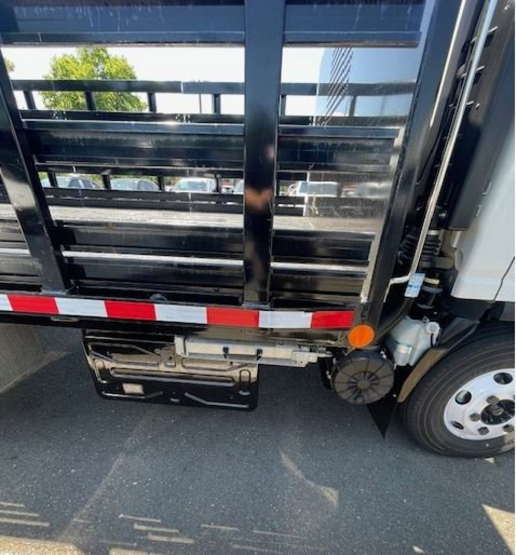 Isuzu NPR HD box truck rear view showing cargo area and rear bumper with red/white reflective tape and tail light area.